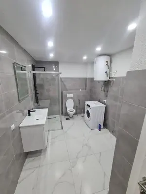 a white bathroom with a toilet and a sink at Apartman Dani in Jajce