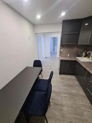 a kitchen with two chairs and a long counter at Apartman Dani in Jajce