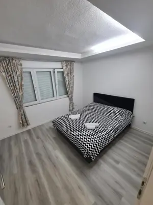 a bedroom with a black and white bed in a room at Apartman Dani in Jajce