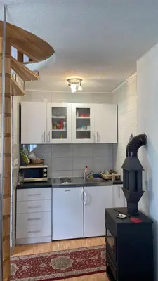 a kitchen with white cabinets and a stove at Vila Damir in Gornja Šišava