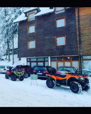 two atvs parked in the snow in front of a building at Vila Damir in Gornja Šišava