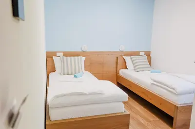 two beds in a room with white sheets at Villa Ali in Illidža