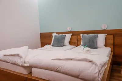 two beds in a room with towels on them at Villa Ali in Illidža