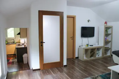 a living room with a door and a tv at Apartman Nadja&Dani in Kulen Vakuf