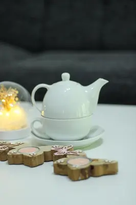 a tea pot on a plate next to cookies at Apartman Nadja&Dani in Kulen Vakuf