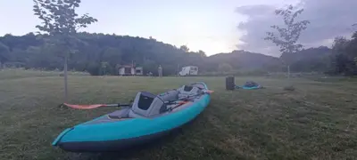 a blue kayak sitting on the grass in a field at Apartman Nadja&Dani in Kulen Vakuf
