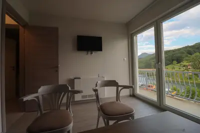 a room with two chairs and a large window at Tadic apartments and rooms by the shore of Rama Lake in Prozor