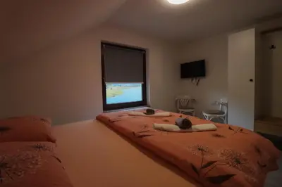a bedroom with a large bed with a television on it at Tadic apartments and rooms by the shore of Rama Lake in Prozor