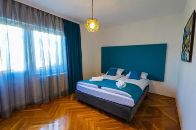 a bedroom with a bed with a blue headboard at Khalilah Apartment 1 in Bihać