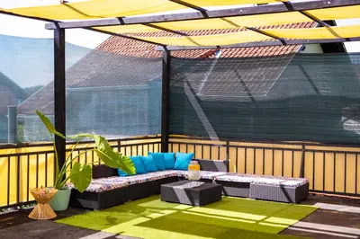 a patio with a couch and a table on a balcony at Khalilah Apartment 1 in Bihać