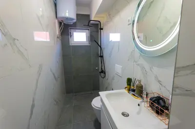 a bathroom with a sink and a toilet and a mirror at Khalilah Apartment 1 in Bihać