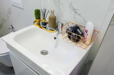 a bathroom sink with a basket on top of it at Khalilah Apartment 1 in Bihać