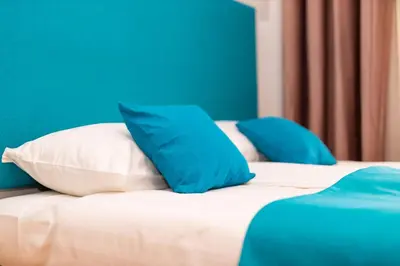 two beds with blue and white pillows on them at Khalilah Apartment 2 in Bihać