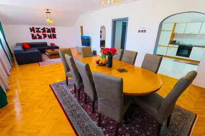 a dining room with a wooden table and chairs at Khalilah Apartment 2 in Bihać