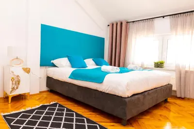 a bedroom with a large bed with a blue headboard at Khalilah Apartment 2 in Bihać