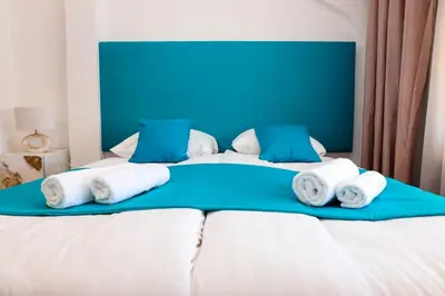 a bed with blue and white pillows on it at Khalilah Apartment 2 in Bihać