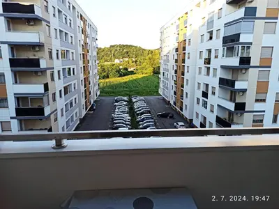 a view from a balcony of a parking lot with buildings at Apartman Oaza in Doboj