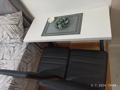 a white table with a bowl of flowers on it at Apartman Oaza in Doboj