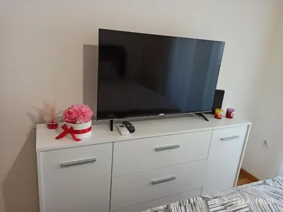 a white dresser with a flat screen tv on it at Apartman Oaza in Doboj