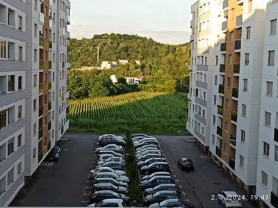 an aerial view of cars parked in a parking lot between two buildings at Apartman Oaza in Doboj