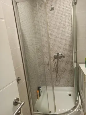 a shower with a glass door in a bathroom at Apartman Oaza in Doboj
