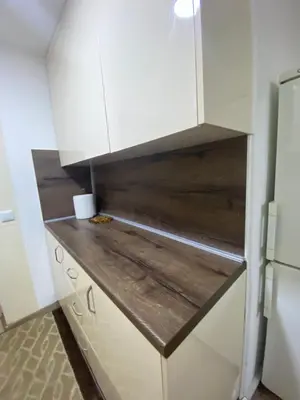 a kitchen with white cabinets and a wooden counter top at Apartment Poturmahala 2 in Travnik