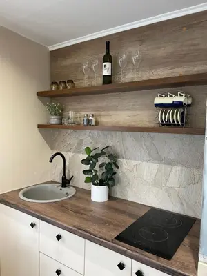 a kitchen counter with a sink and wine glasses at Bungalovi izvor Plive 2 in Šipovo
