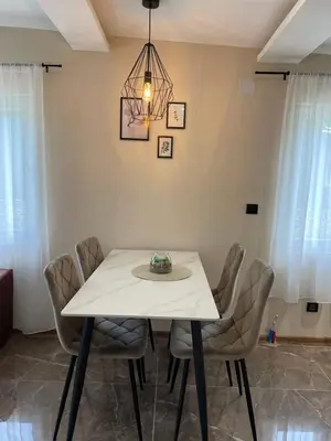 a dining room with a white table and chairs at Bungalovi izvor Plive 2 in Šipovo