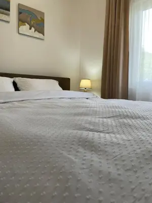 a bedroom with a white bed with a window at Bungalovi izvor Plive 3 in Šipovo