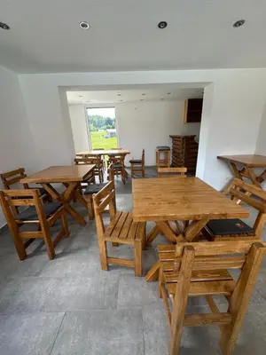 a group of wooden tables and chairs in a room at Luxury Glamping Grabovica - Vital Resort in Skender Vakuf