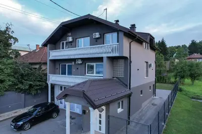 a house with a car parked in front of it at Evergreen Apartments in Visoko