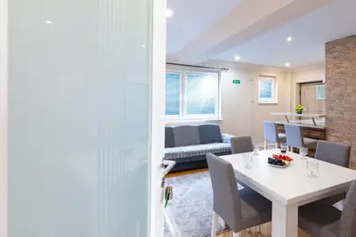 a dining room and living room with a table and chairs at Evergreen Apartments in Visoko