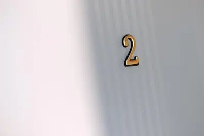 a gold number two on a white background at Evergreen Apartments in Visoko