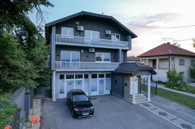 a car parked in front of a house with a garage at Evergreen Apartments in Visoko