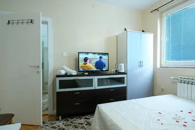 a bedroom with a dresser with a tv on it at Evergreen Apartments in Visoko