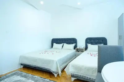 two beds in a room with blue walls at Evergreen Apartments in Visoko