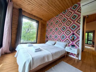 a bedroom with a bed and a wall with a window at ORAH HOUSE, a unique and unforgettable vacation on a private island in Bihać