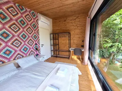 a bedroom with a bed and a large window at ORAH HOUSE, a unique and unforgettable vacation on a private island in Bihać