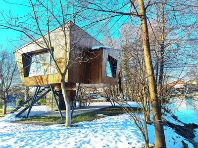 a tree house sitting on a tree in the snow at ORAH HOUSE, a unique and unforgettable vacation on a private island in Bihać