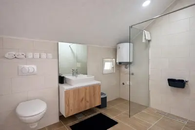 a bathroom with a toilet and a sink and a shower at Apartmani Sun & Moon in Žepče