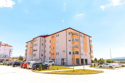 a building with cars parked in a parking lot at Pronađi svoj mir in Livno