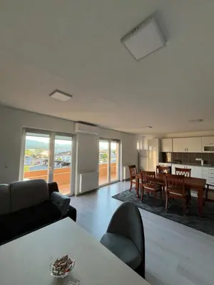a living room with a table and a dining room at Apartment M&S Gračanica in Gračanica