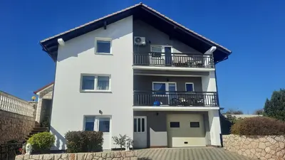 a white house with a balcony at Apartman Ružica in Tomislavgrad