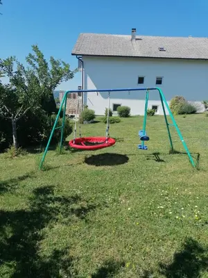 a playground with two swings in a yard at Apartman Ružica in Tomislavgrad