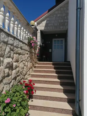 a stairway leading to a house with a door and flowers at Apartman Ružica in Tomislavgrad