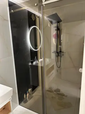 a shower with a glass door in a bathroom at JB apartman Živinice in Živinice