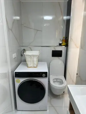 a small bathroom with a microwave and a toilet at JB apartman Živinice in Živinice