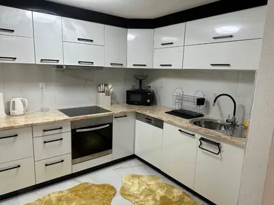 a kitchen with white cabinets and a sink at JB apartman Živinice in Živinice