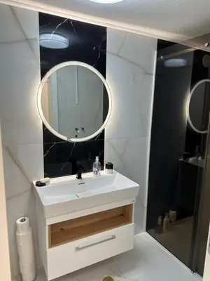 a bathroom with a white sink and a mirror at JB apartman Živinice in Živinice