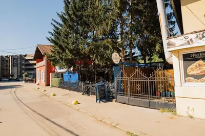 a street with a fence and a building at Apartment Vela in Tuzla